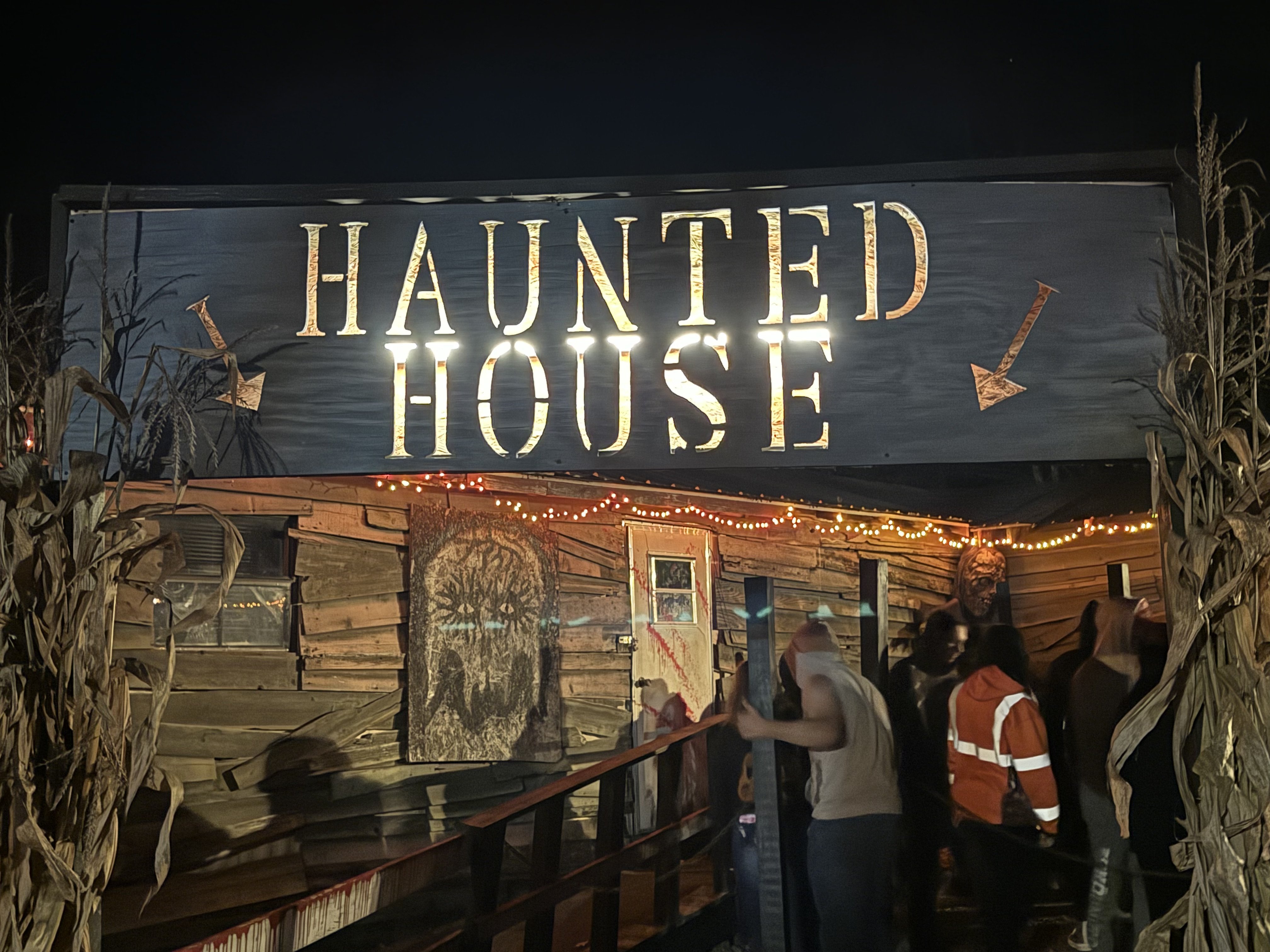 Haunted house entrance with corn stalks at night